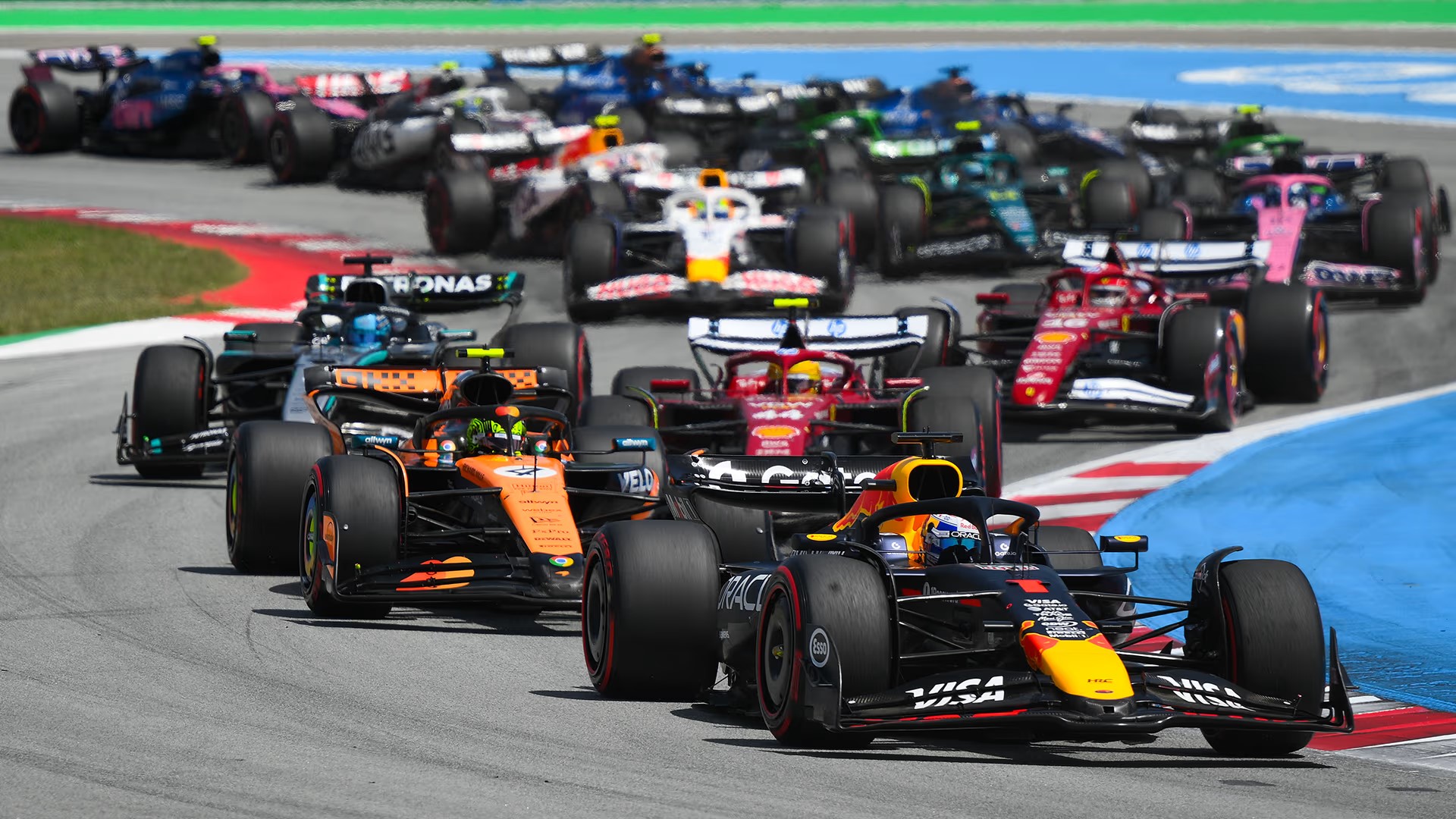 Formula 1 cars racing through the opening corner of a grand prix